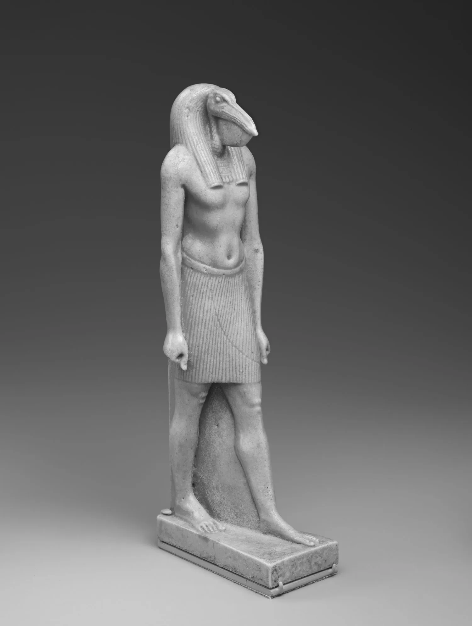 Egyptian faience statuette: an ibis-headed man, standing, with one foot forward.